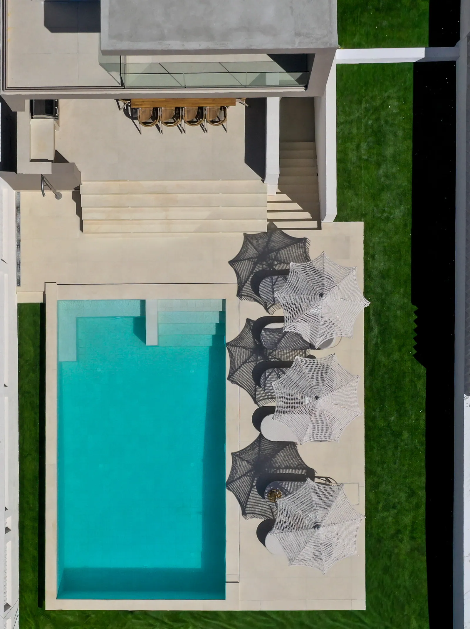 Aerial view of the pool lined with woven umbrellas
