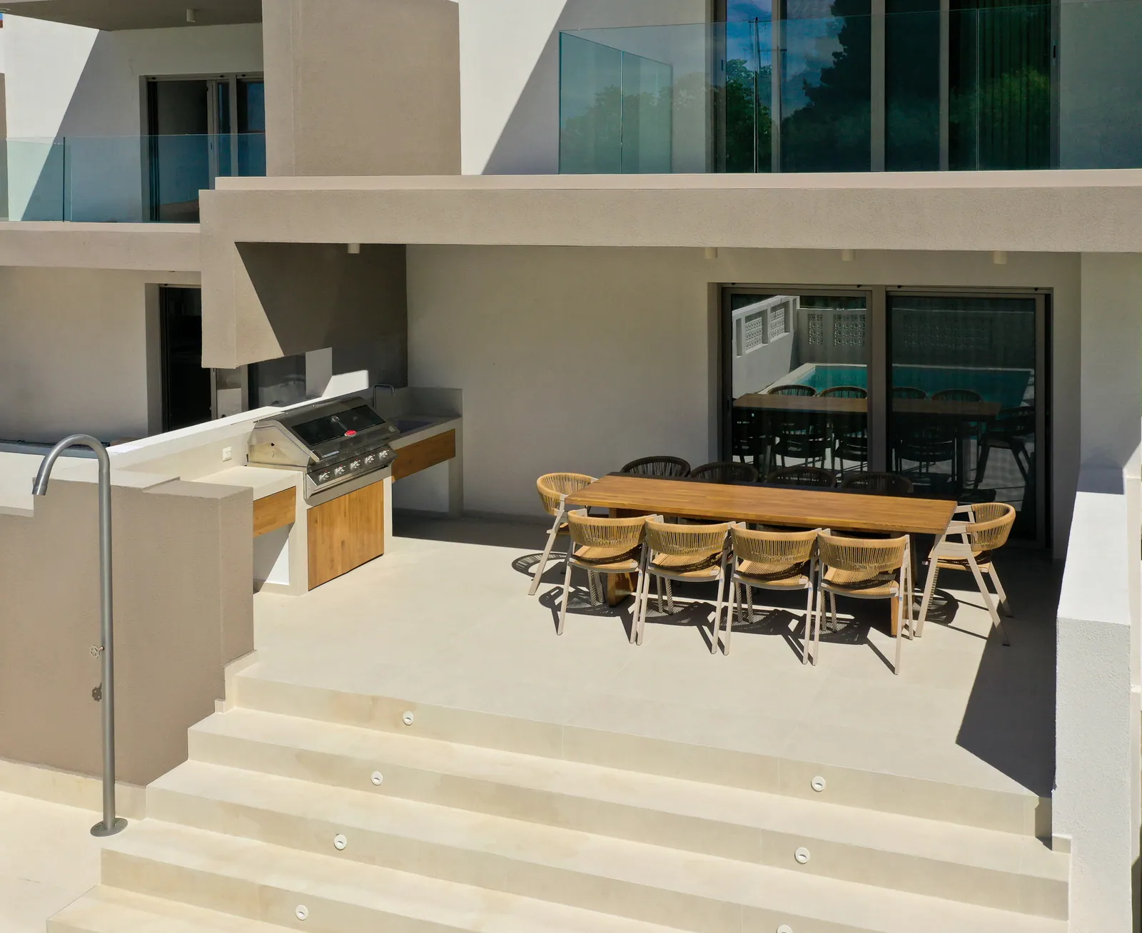 Terrace with outdoor kitchen and a long dining table, seen from above