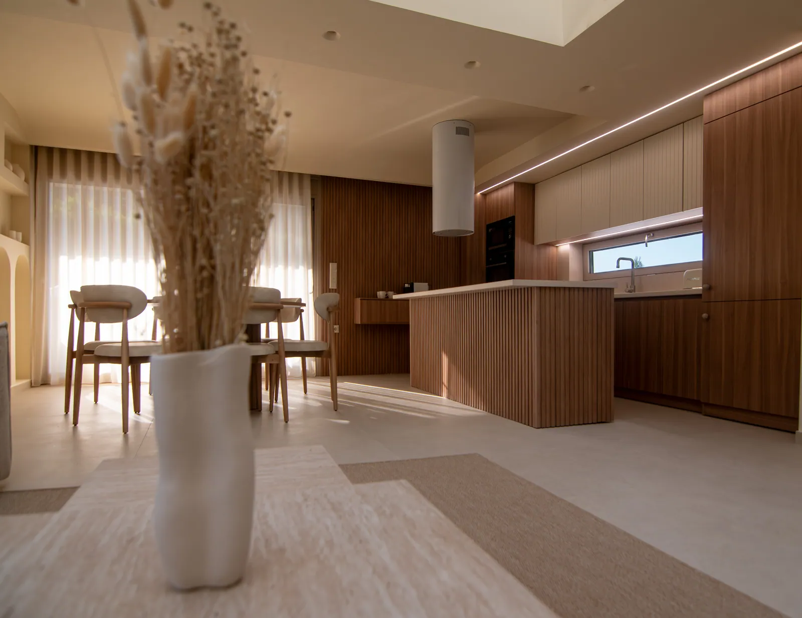 Dining area with dried pampas and a wooden kitchen