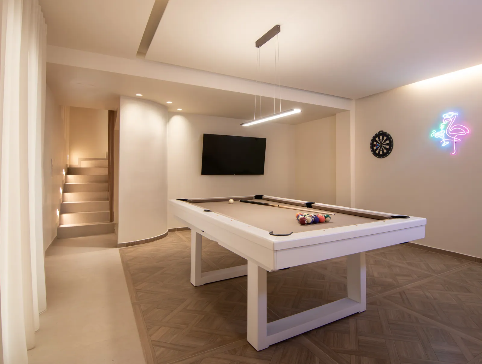 Games room with a pool table and neon sign