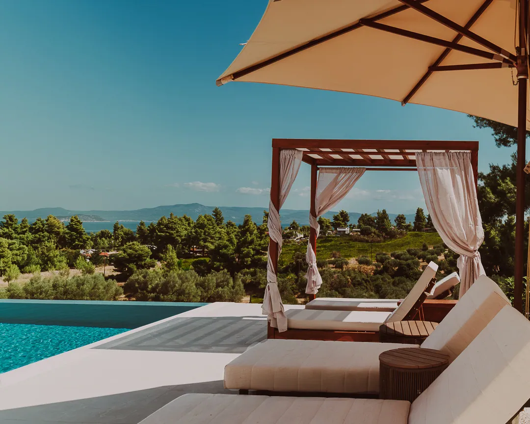 Pergola daybed under a parasol, overlooking the sea