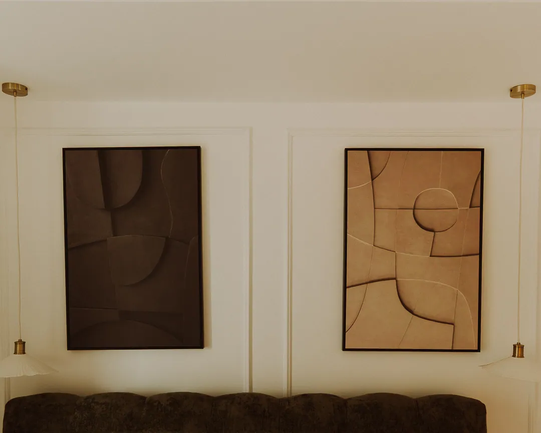 Sculpted relief artworks above a velvet sofa