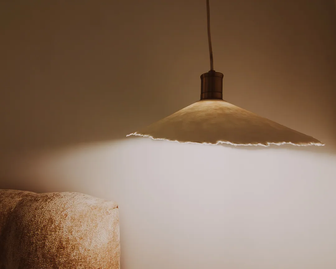 A paper pendant lamp casting soft light on the wall